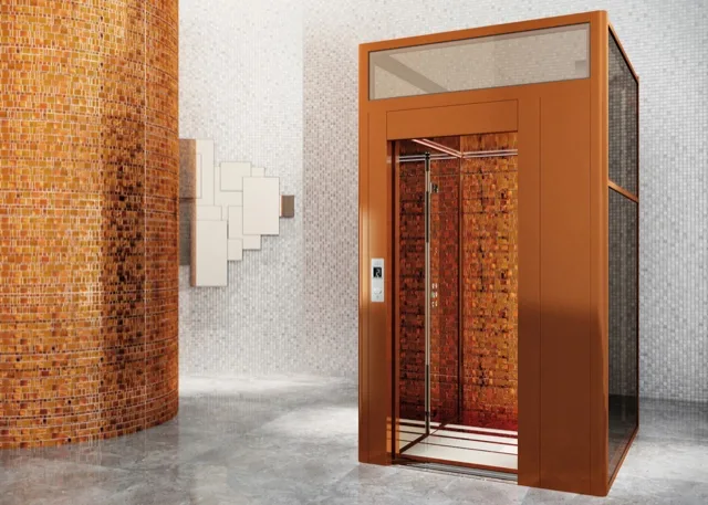 Copper-toned elevator cab set in a mosaic wall