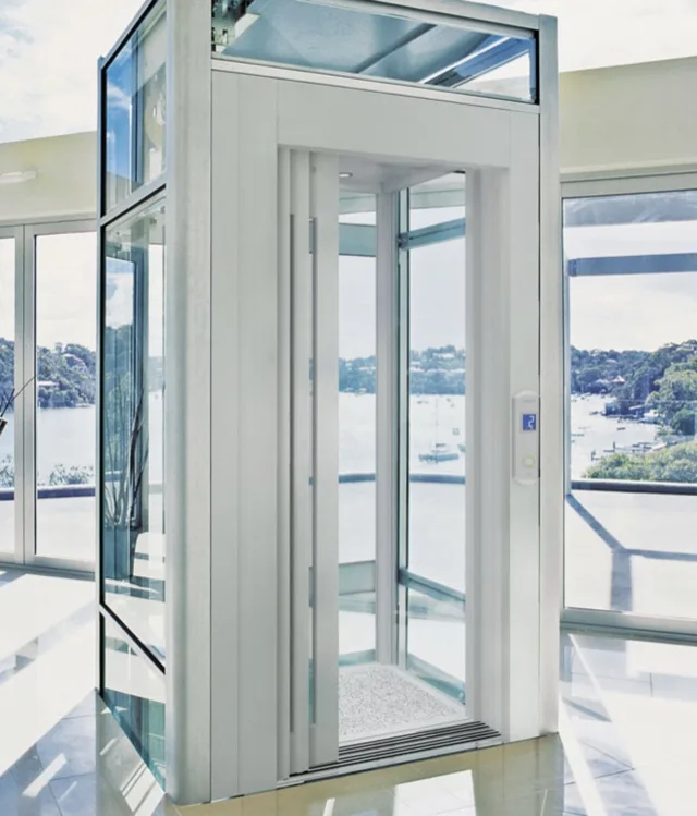 White-framed glass elevator with its doors open in a bright room