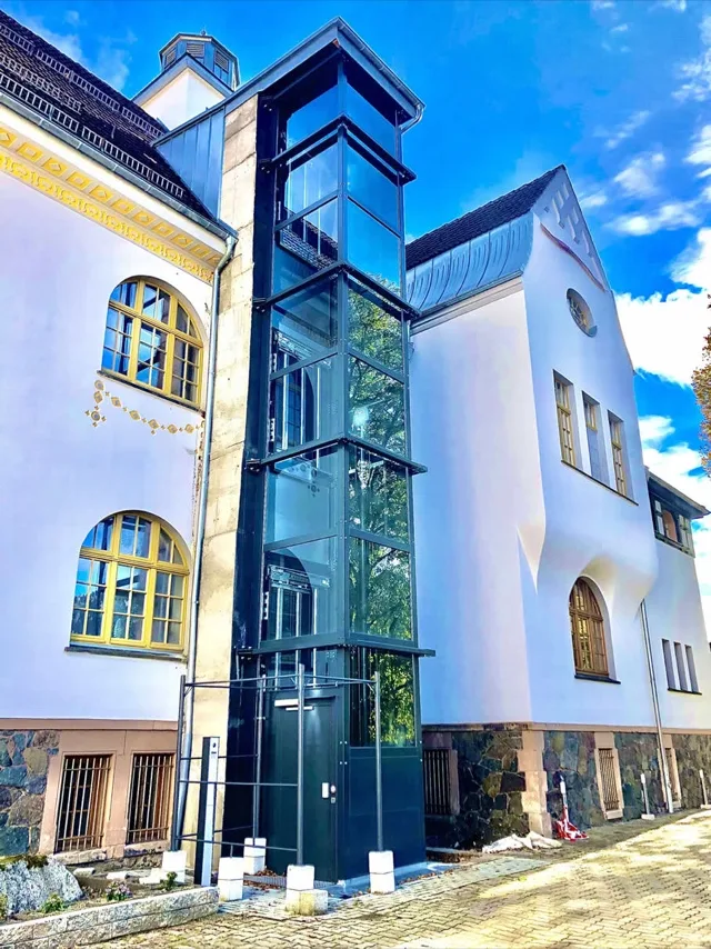 Glass elevator structure added to the outside of a house