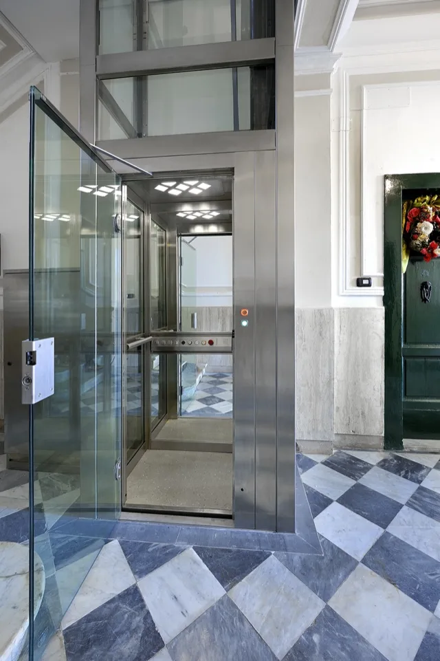 Panoramic glass elevator in a hall with a checkerboard floor